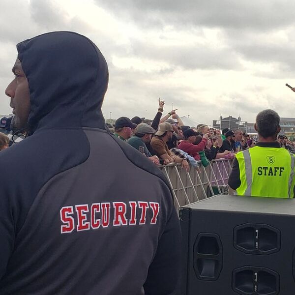 Security officer posted at the front barricade of an outdoor music festival crowd