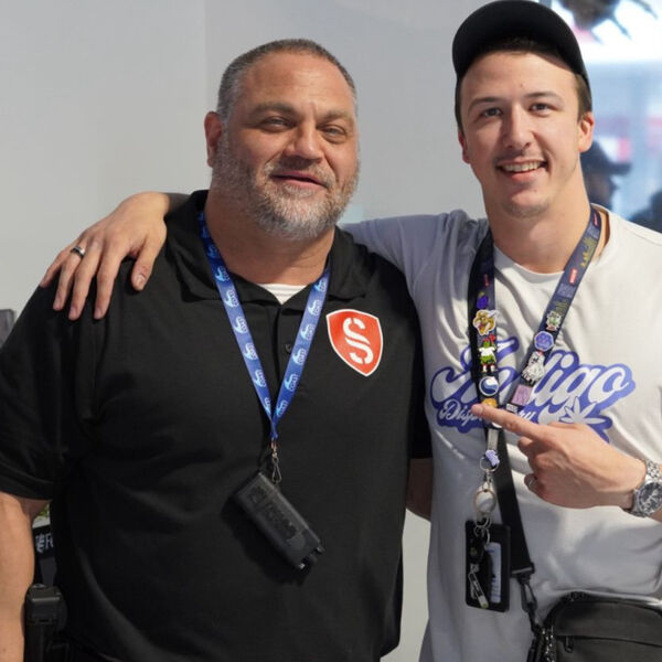 Semper Secure officer posing with a guest at an indoor event
